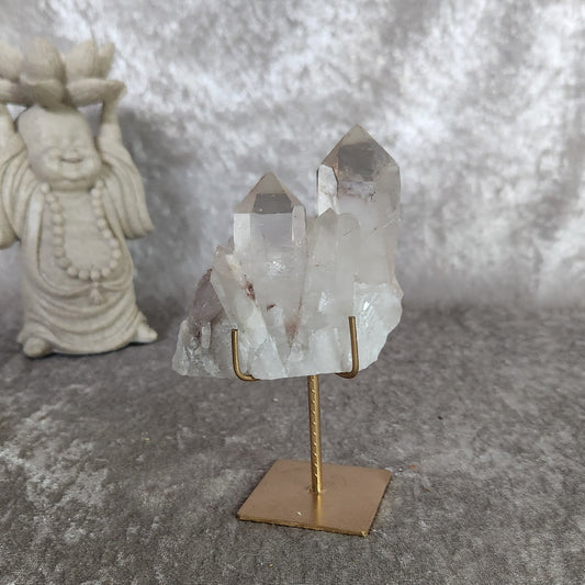 Brazilian quartz cluster with soft lodolite inclusions displayed on gold metal stand