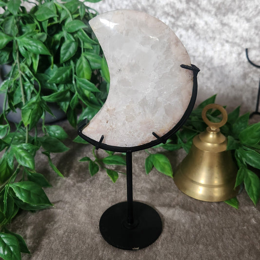 Polished Clear Quartz crescent moon displayed on black metal stand