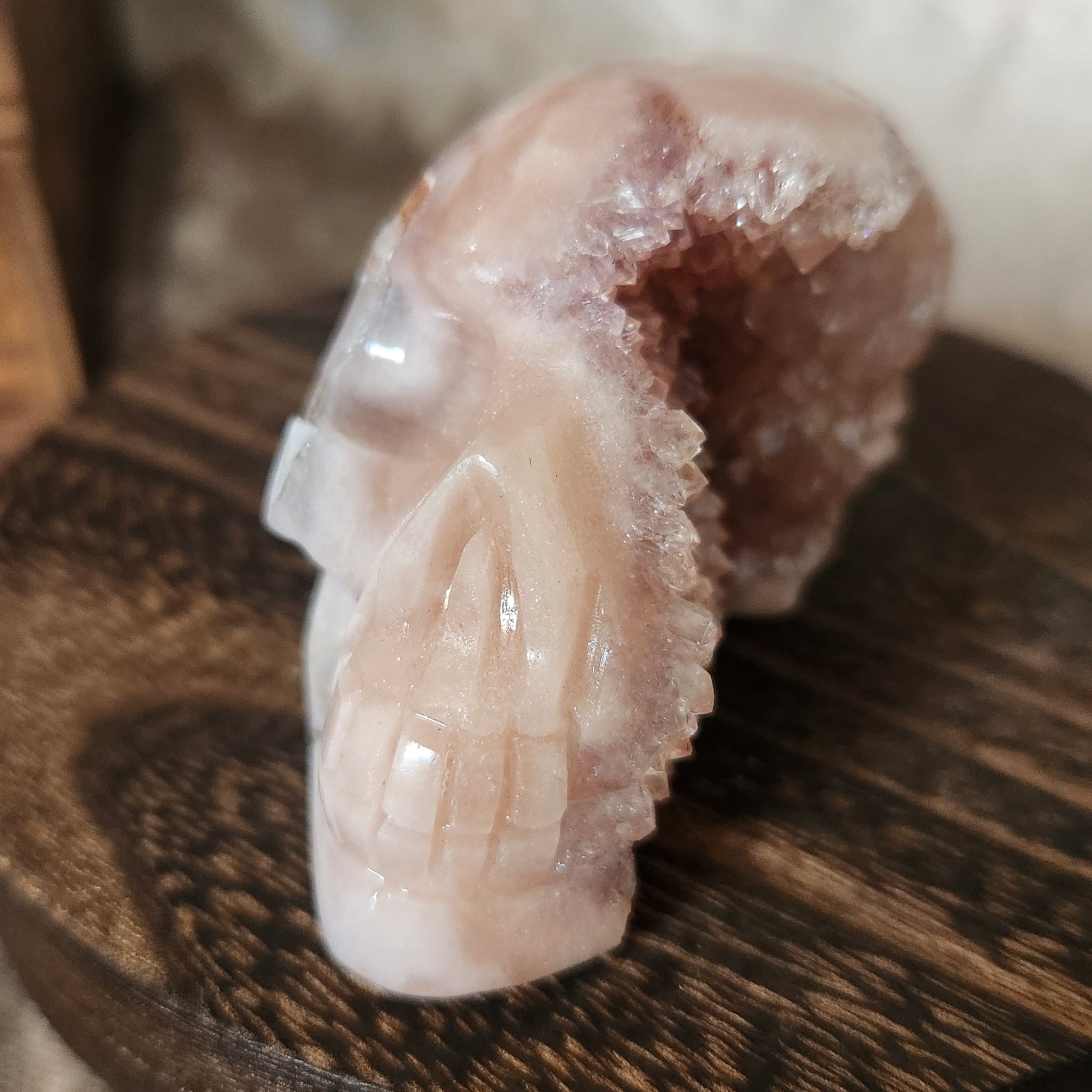 Polished pink amethyst skull crystal with druzy inclusions