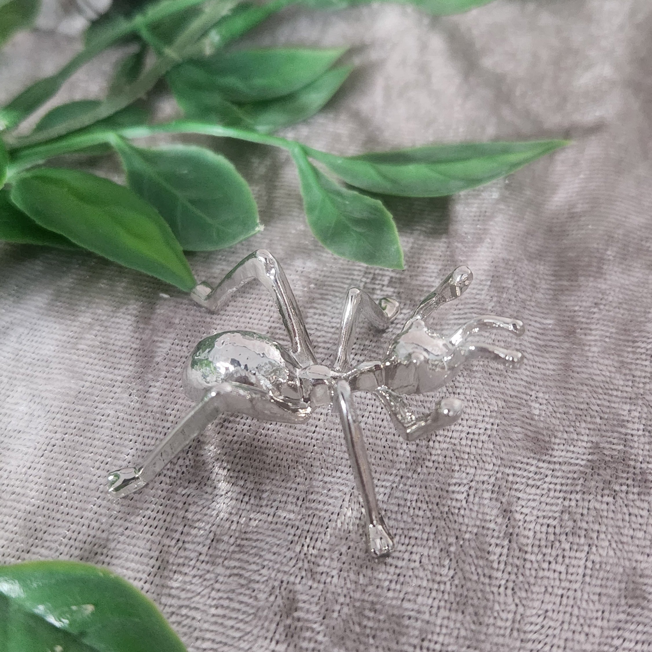 Silver ant sphere holder with crystal sphere on velvet background