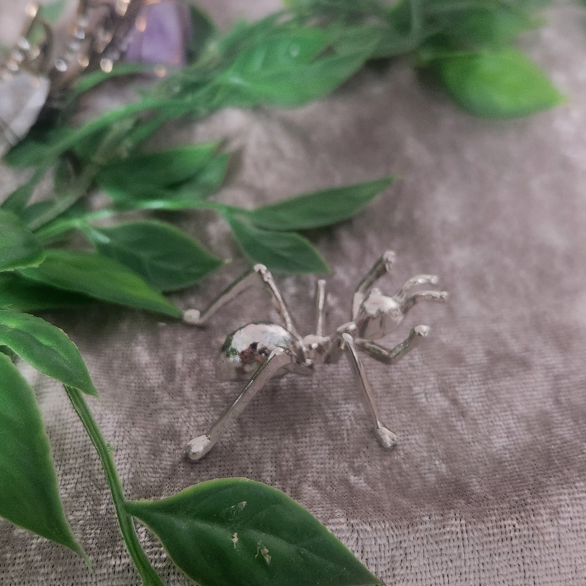 Cute ant used to display crystal spheres in boho decor styled with greenery and velvet background