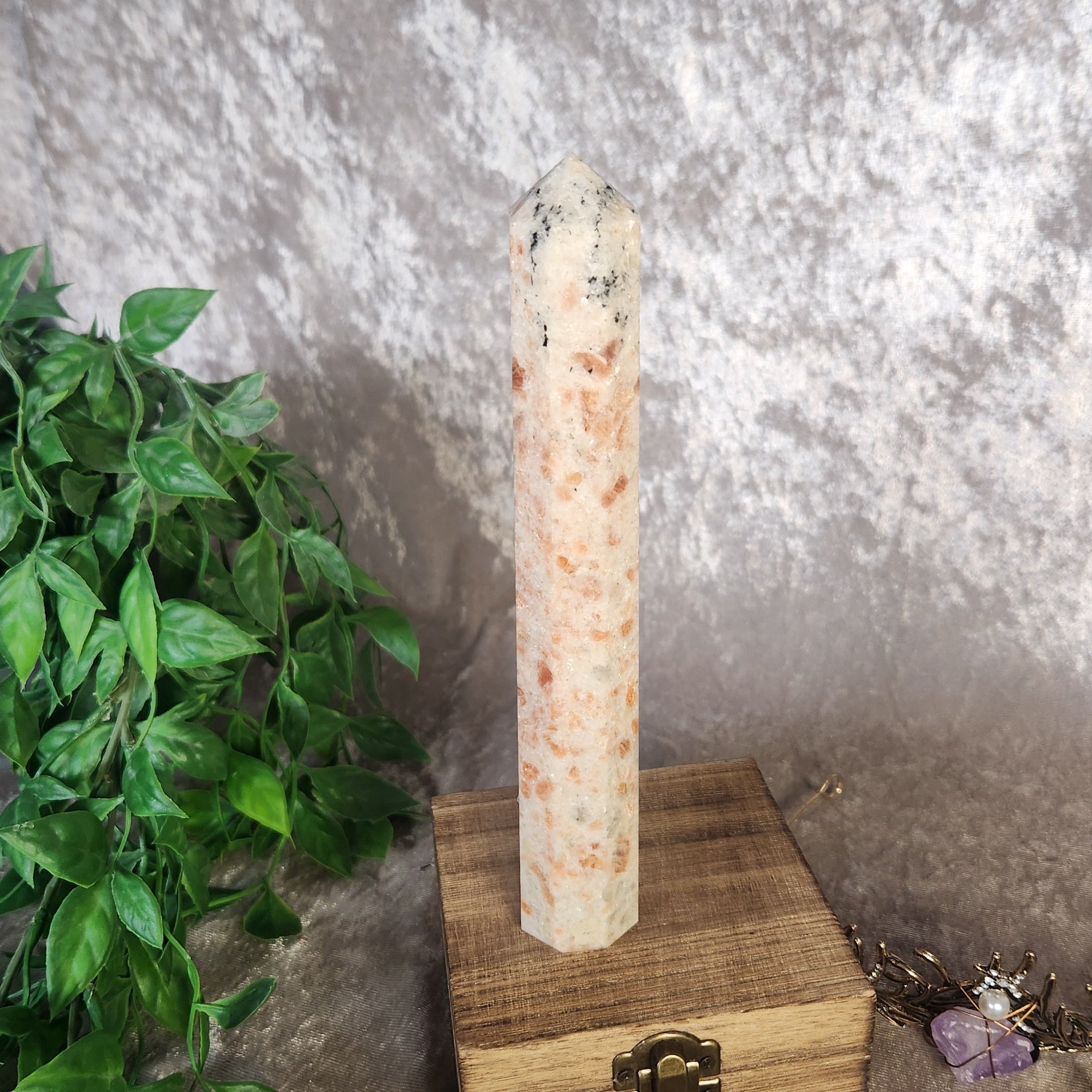 Sunstone tower set on vintage wooden box with crystal tiara and greenery in the background