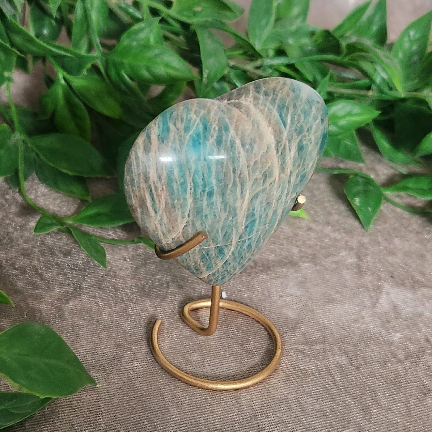 Amazonite heart crystal on stand styled with greenery