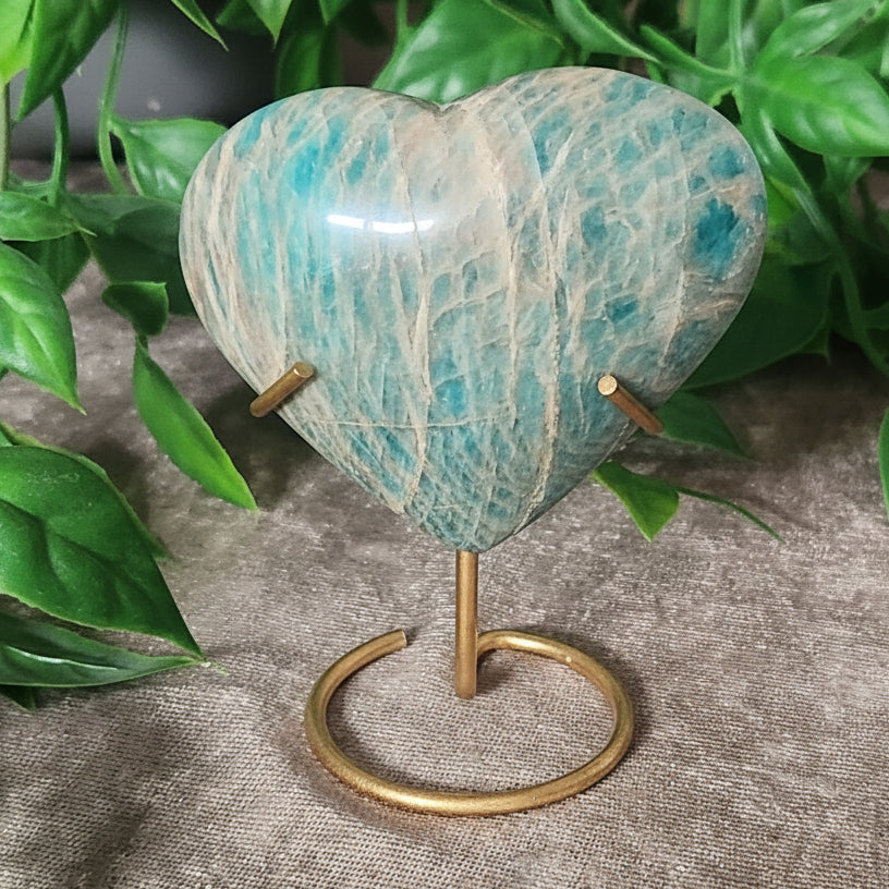 Amazonite heart with blue green tones displayed on gold tone metal stand