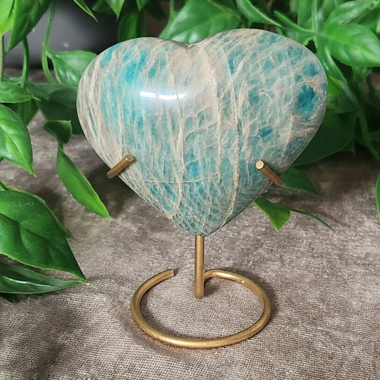 Amazonite heart with blue green tones displayed on gold tone metal stand