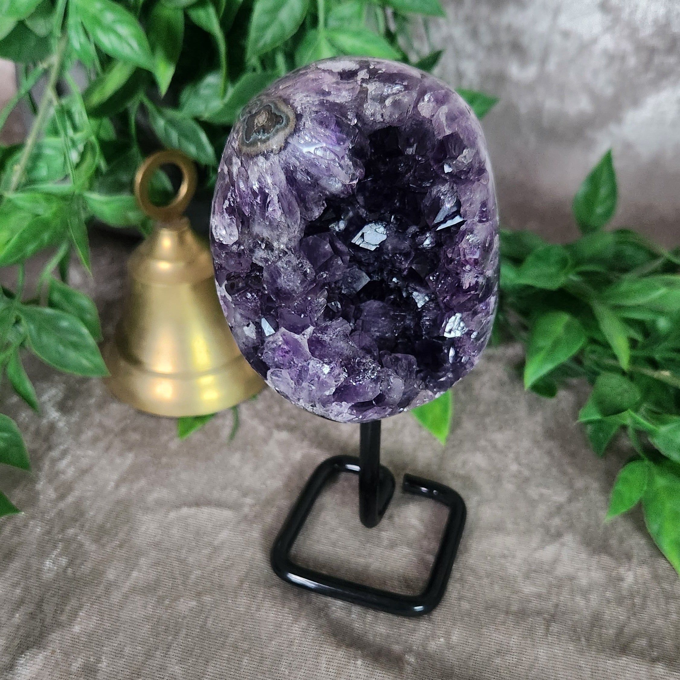 Amethyst crystal geode on stand featuring rich violet druzy clusters for altar or home display