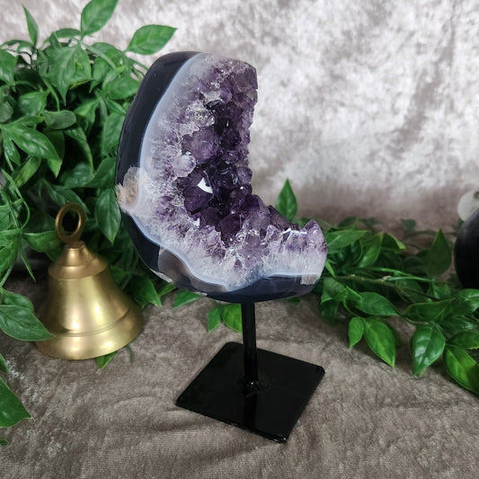 Amethyst druzy geode on black metal stand featuring deep purple crystal points and polished agate edge