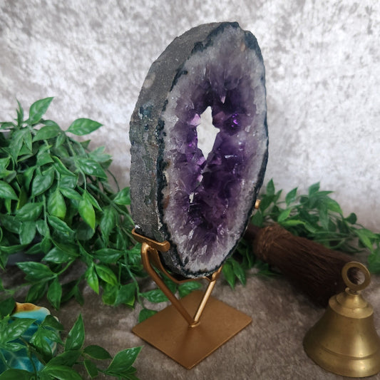 Angled view of amethyst portal on gold stand showing layered crystal formation and natural banding
