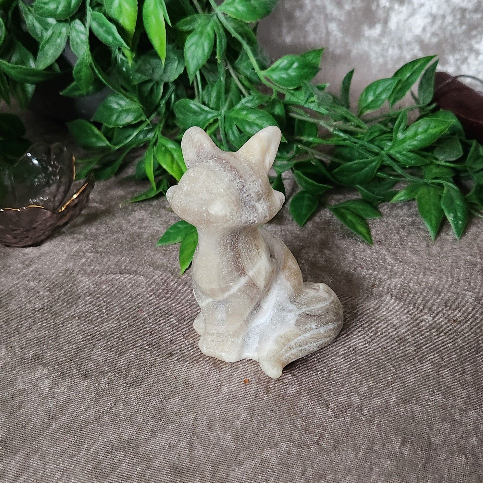 Onyx calcite fox figurine displaying soft translucency and flowing stone layers