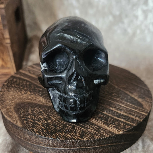 Black Rose Fluorite crystal skull — front angle showing carved teeth and polished dark surface.