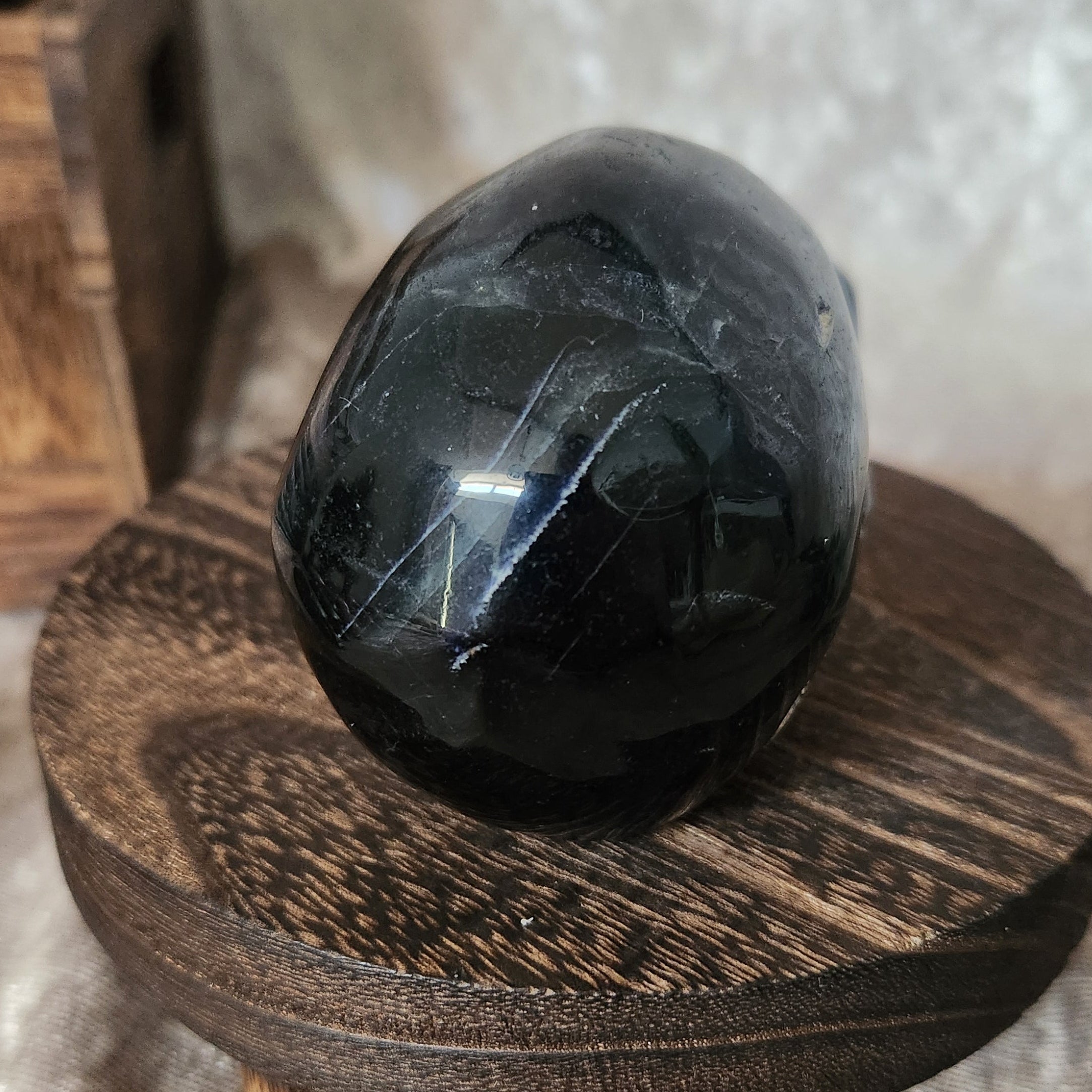 Black Rose Fluorite skull — back angle revealing polished curves and faint rose fluorite veining.