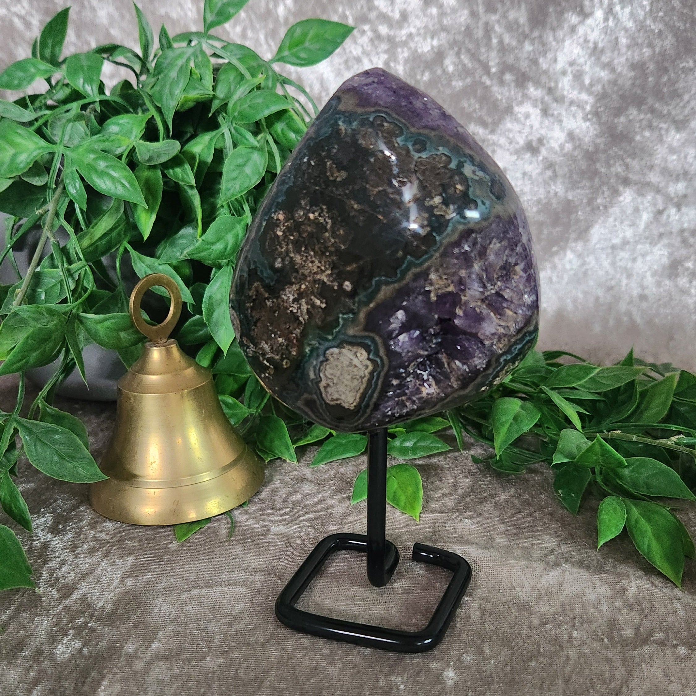 Brazilian amethyst portal geode on stand featuring dark purple crystal points and natural cavern opening