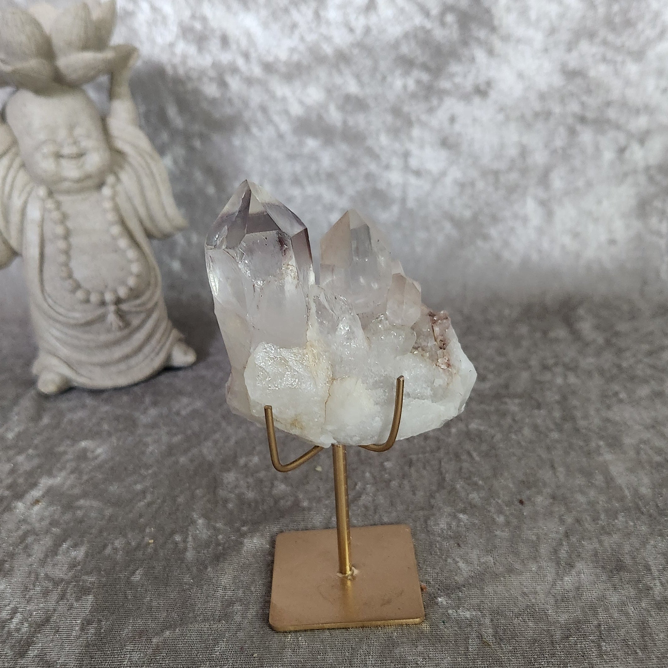 Clear quartz cluster from Brazil with gentle lodolite inclusions on display stand