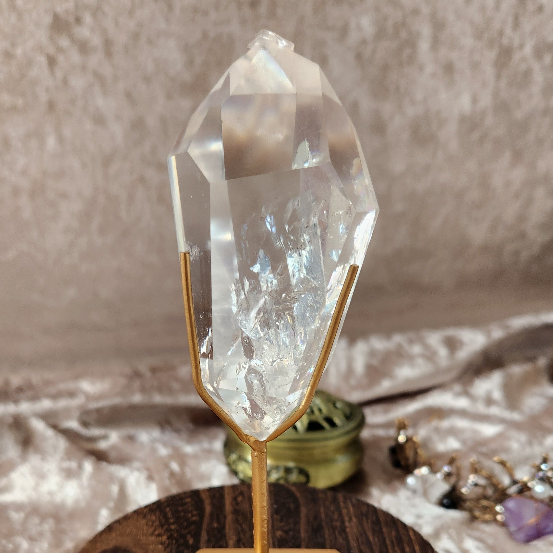 Brazilian clear quartz point on gold stand with natural internal inclusions