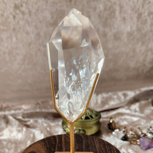 Brazilian clear quartz point on gold stand with natural internal inclusions