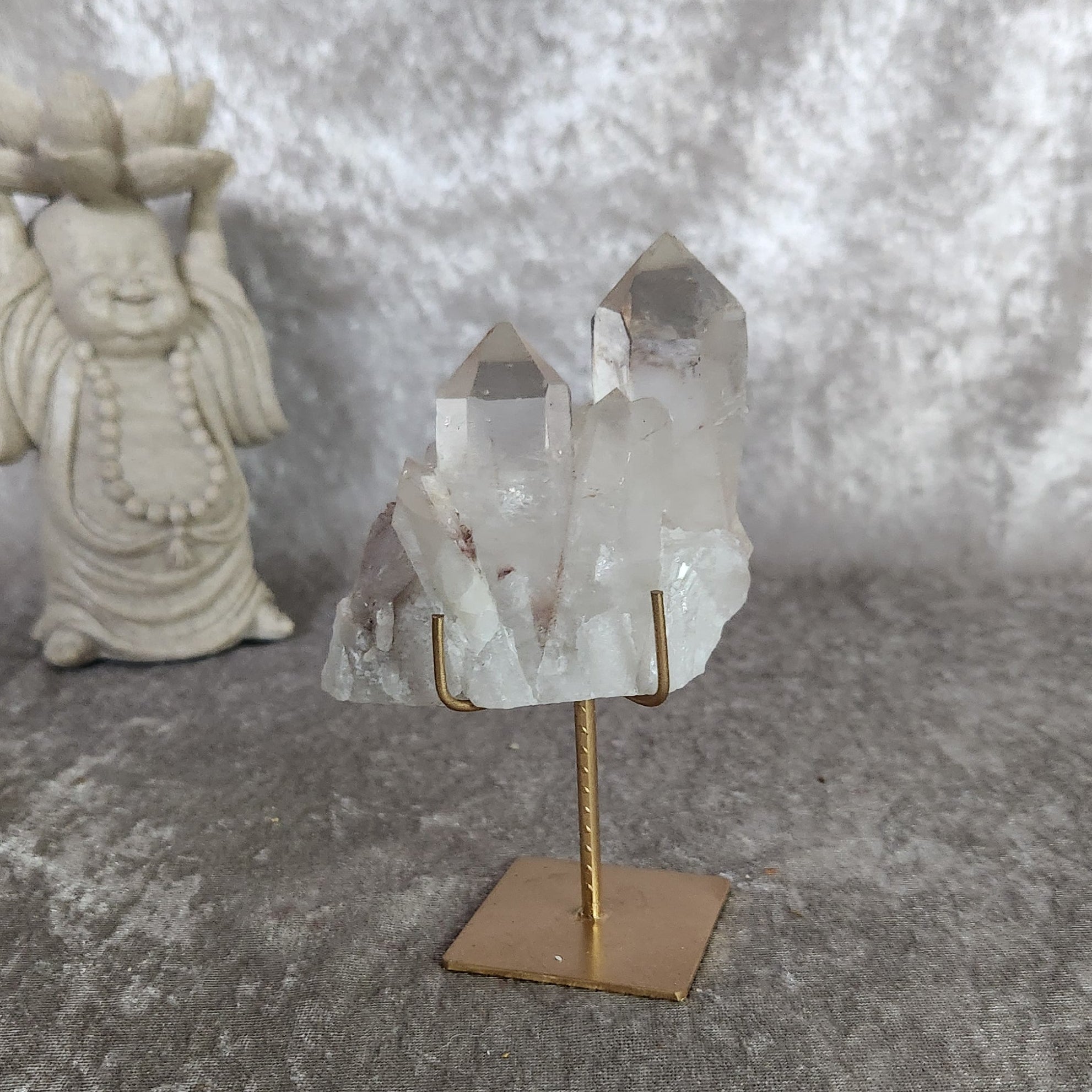 Brazilian quartz cluster with soft lodolite inclusions displayed on gold metal stand
