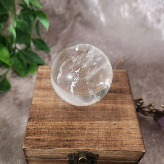 Polished clear quartz sphere showcasing internal clarity and inclusions