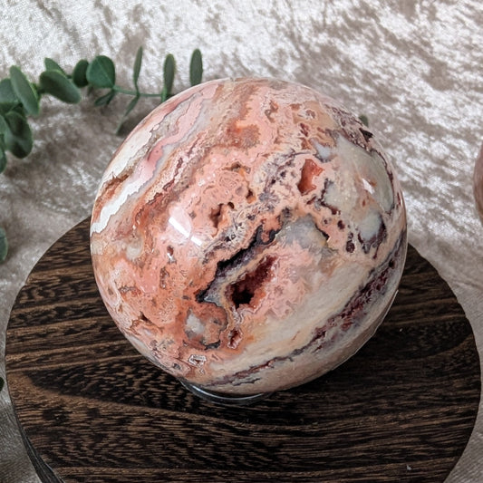 Close up of crazy lace agate crystal sphere showing intricate banding and natural mineral texture