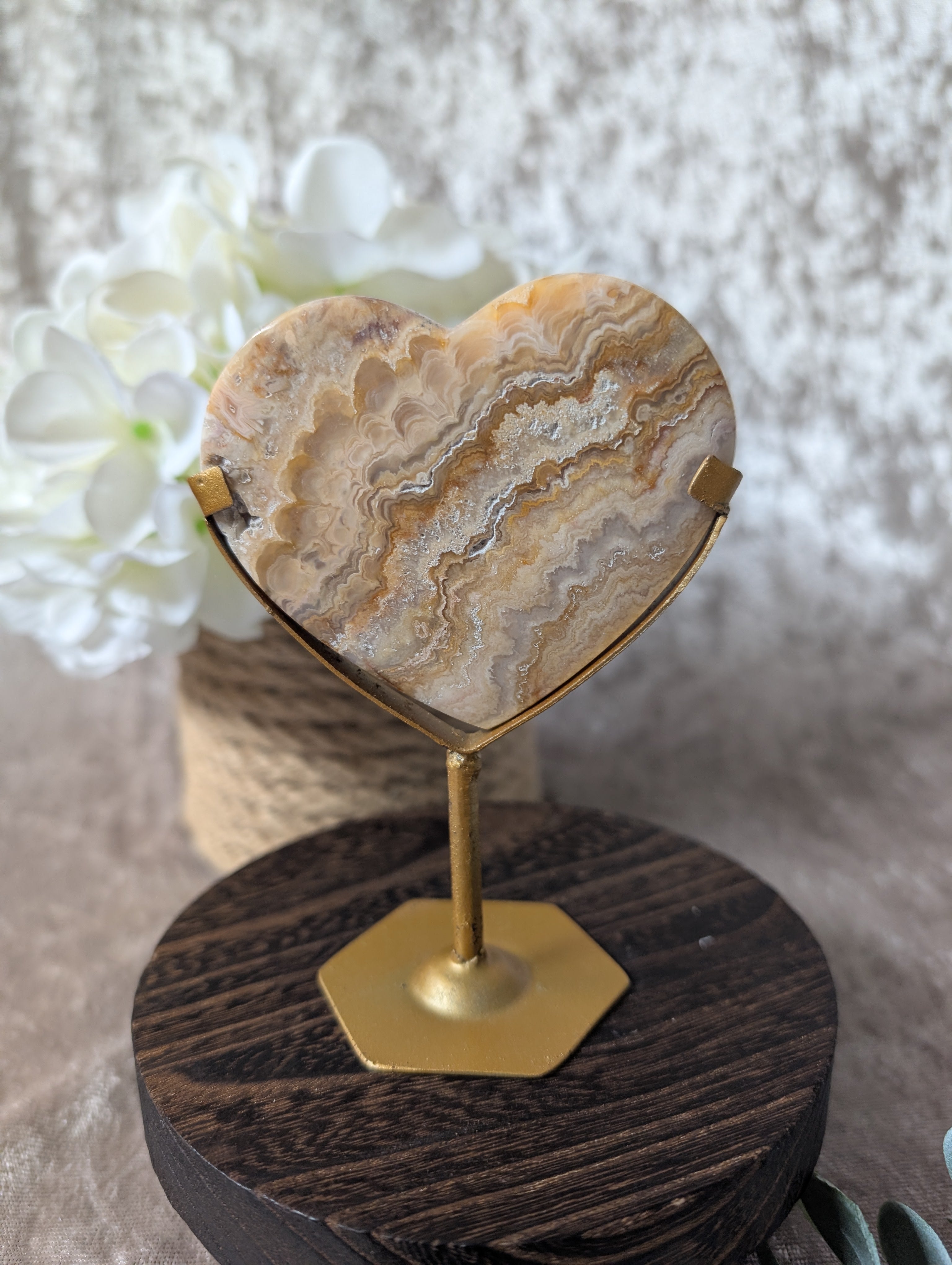 Crazy Lace Agate Heart on gold stand with beautiful banding in neutral tones in boho luxe decor setting