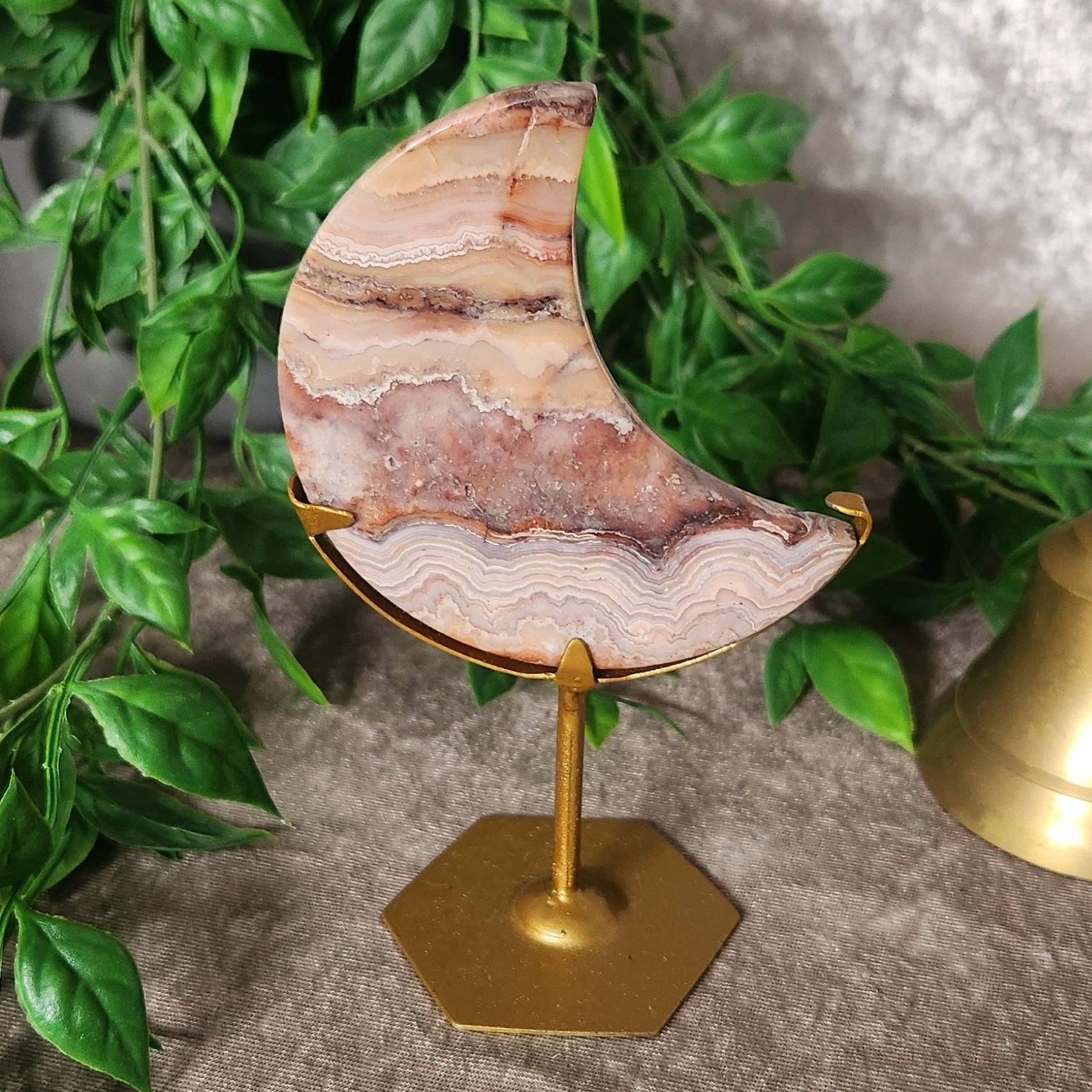 Crazy Lace Agate moon carving on gold stand with natural banded patterns