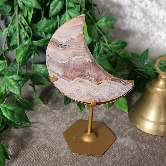 Crazy lace agate moon carving on stand with natural banded patterns