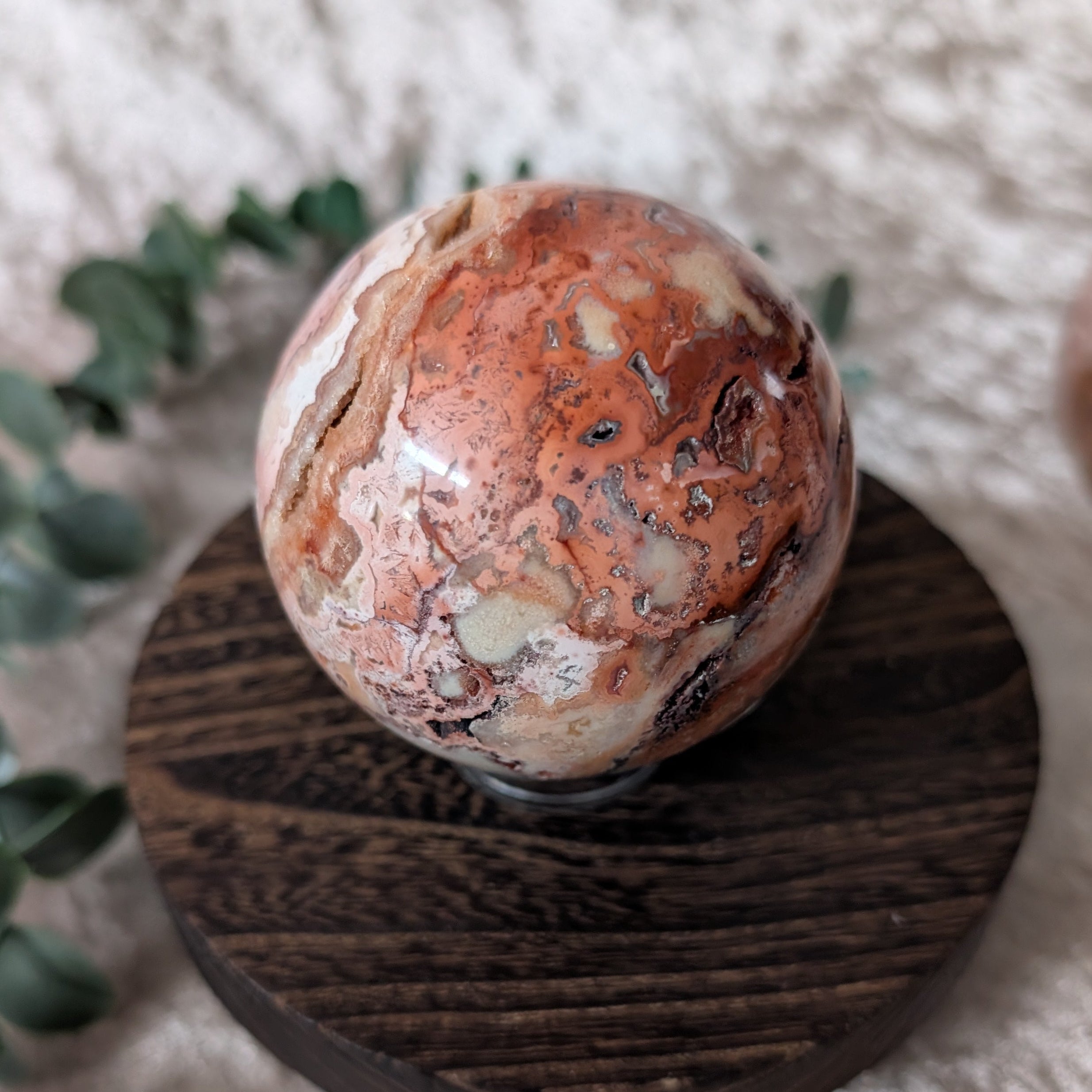 Detailed view of crazy lace agate sphere highlighting natural lace-like banding and colour variation
