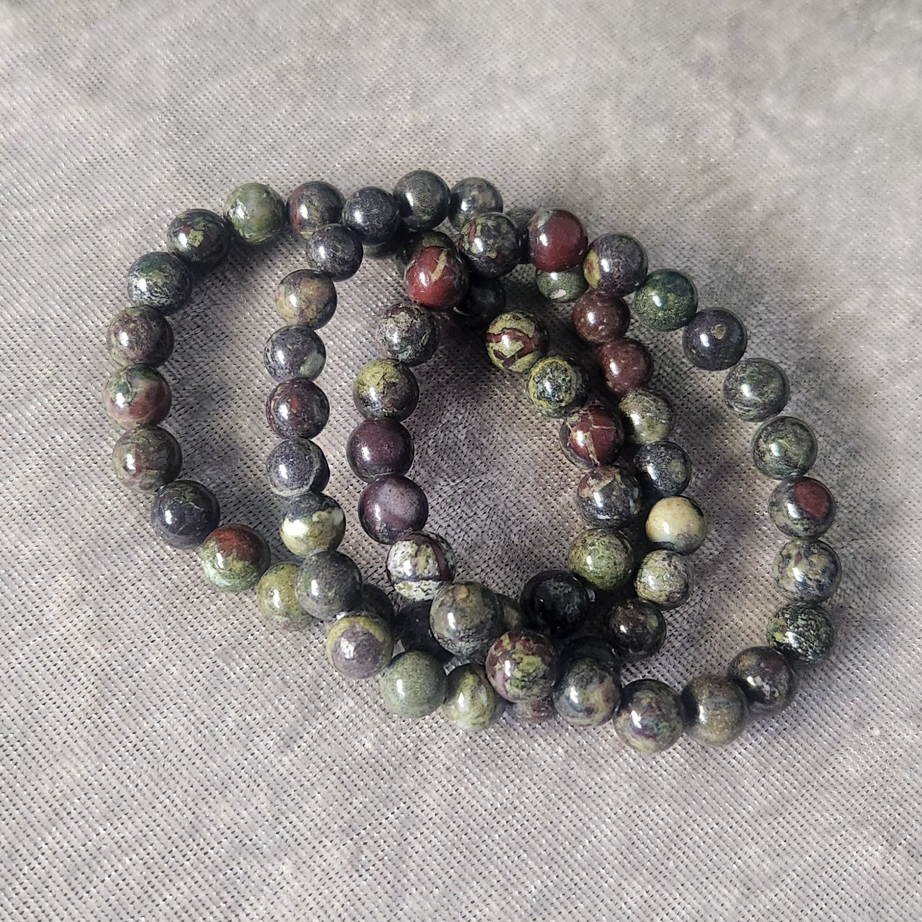 Natural Dragon’s Blood Jasper crystal bracelet displayed on a neutral background