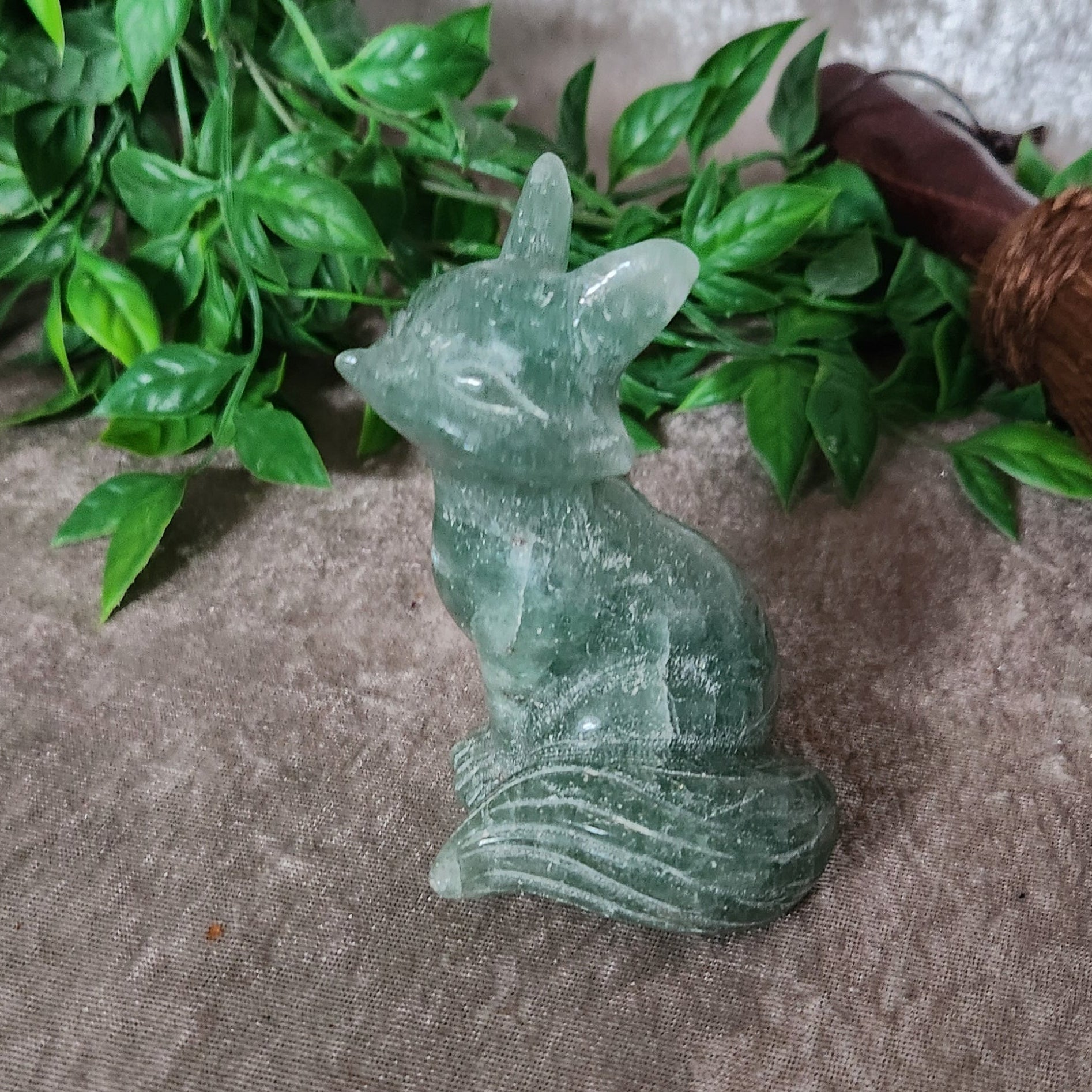 Green fluorite fox carving with translucent crystal body and soft green colour variation