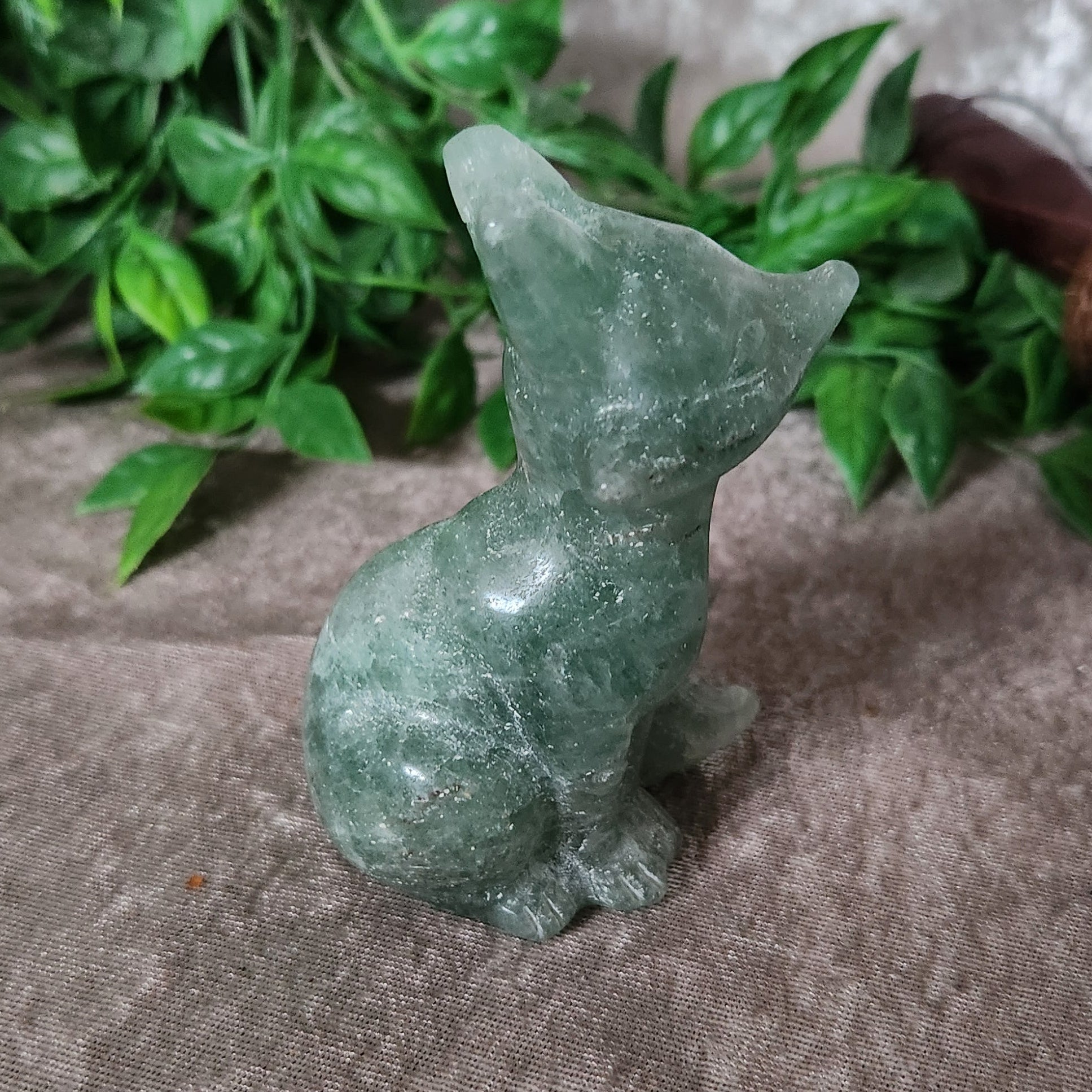 Hand carved green fluorite fox figurine showing natural clarity and polished surface