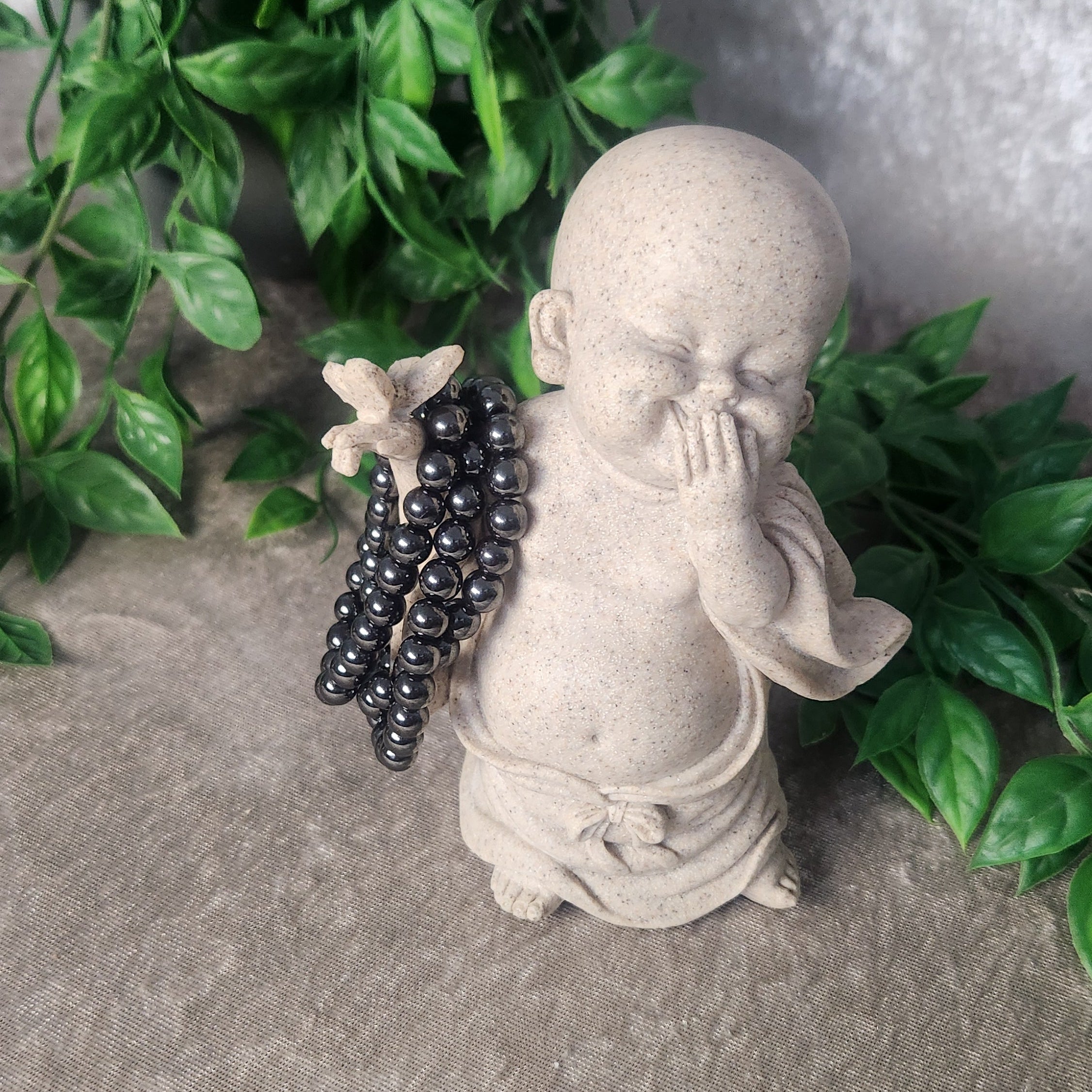 Hematite bracelet with polished 8 mm beads photographed on a stand