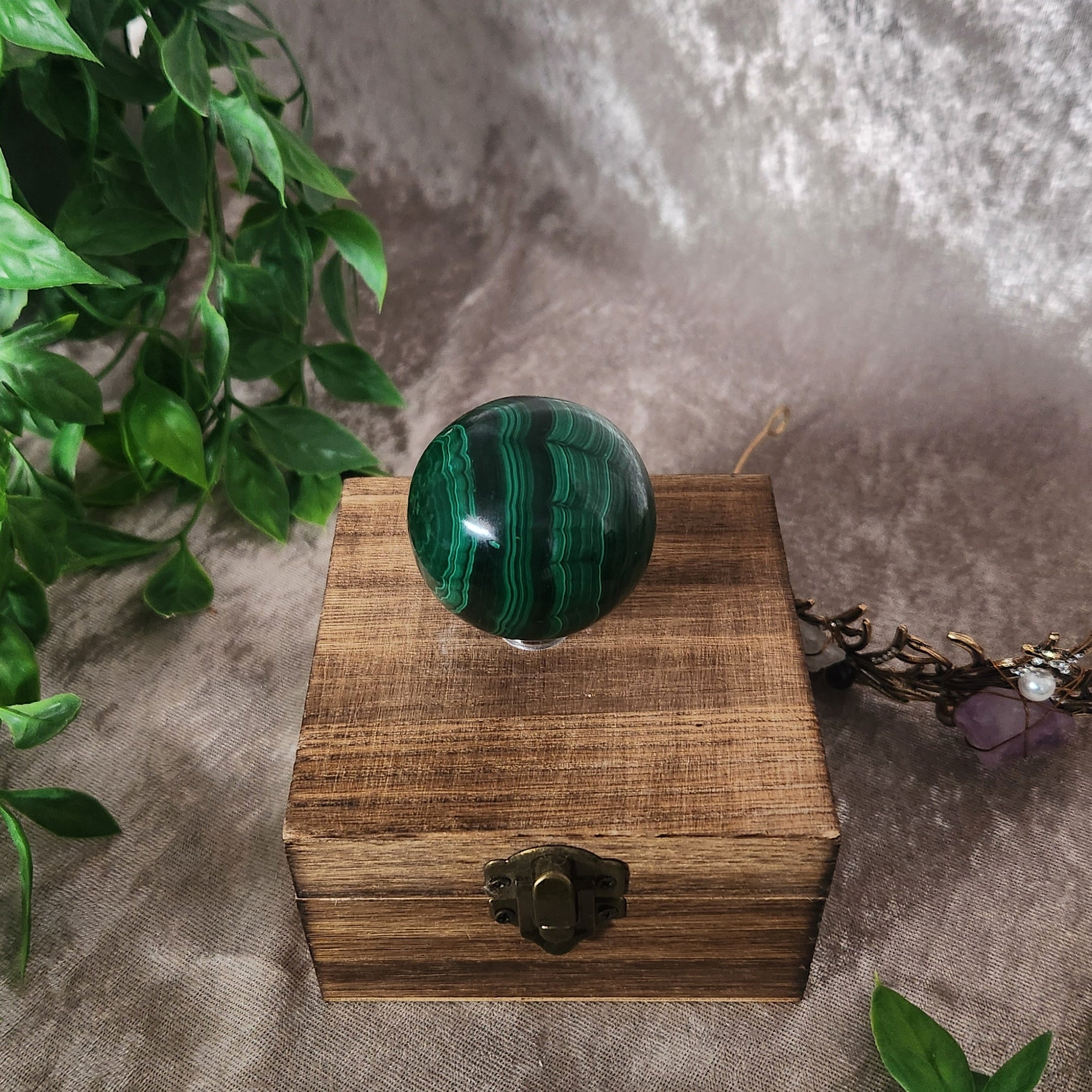 Green malachite crystal sphere photographed on neutral background