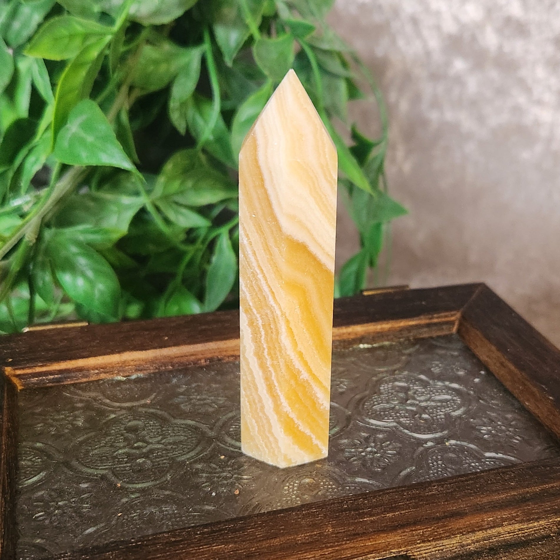 Polished orange banded calcite crystal tower showing natural orange and white banding