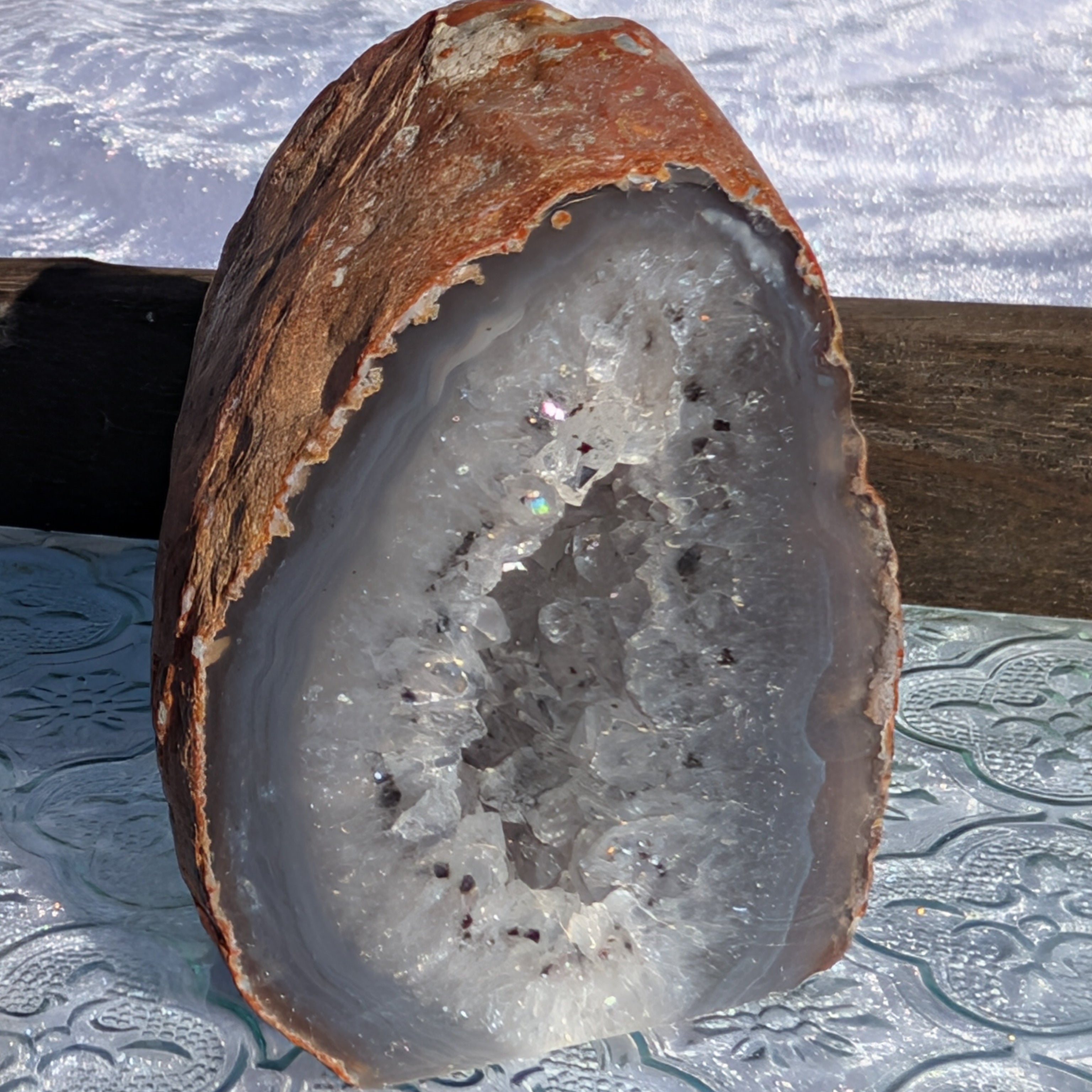 Natural Agate Geode sparkling in sunlight set on vintage glass tray