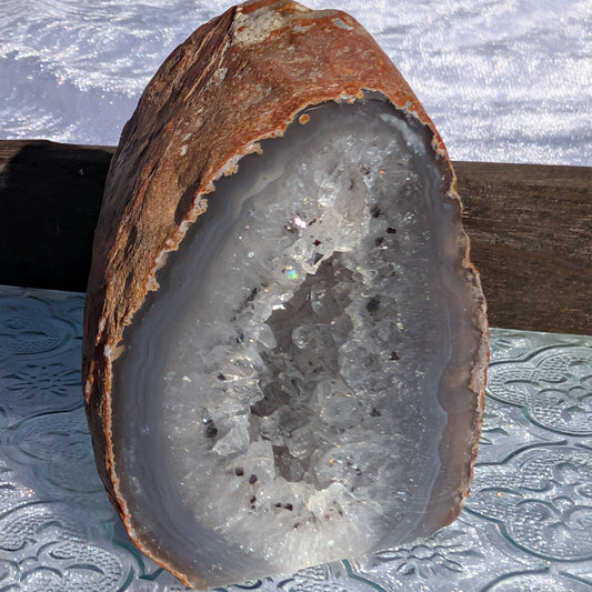 Natural Agate Geode sparkling in sunlight set on vintage glass tray