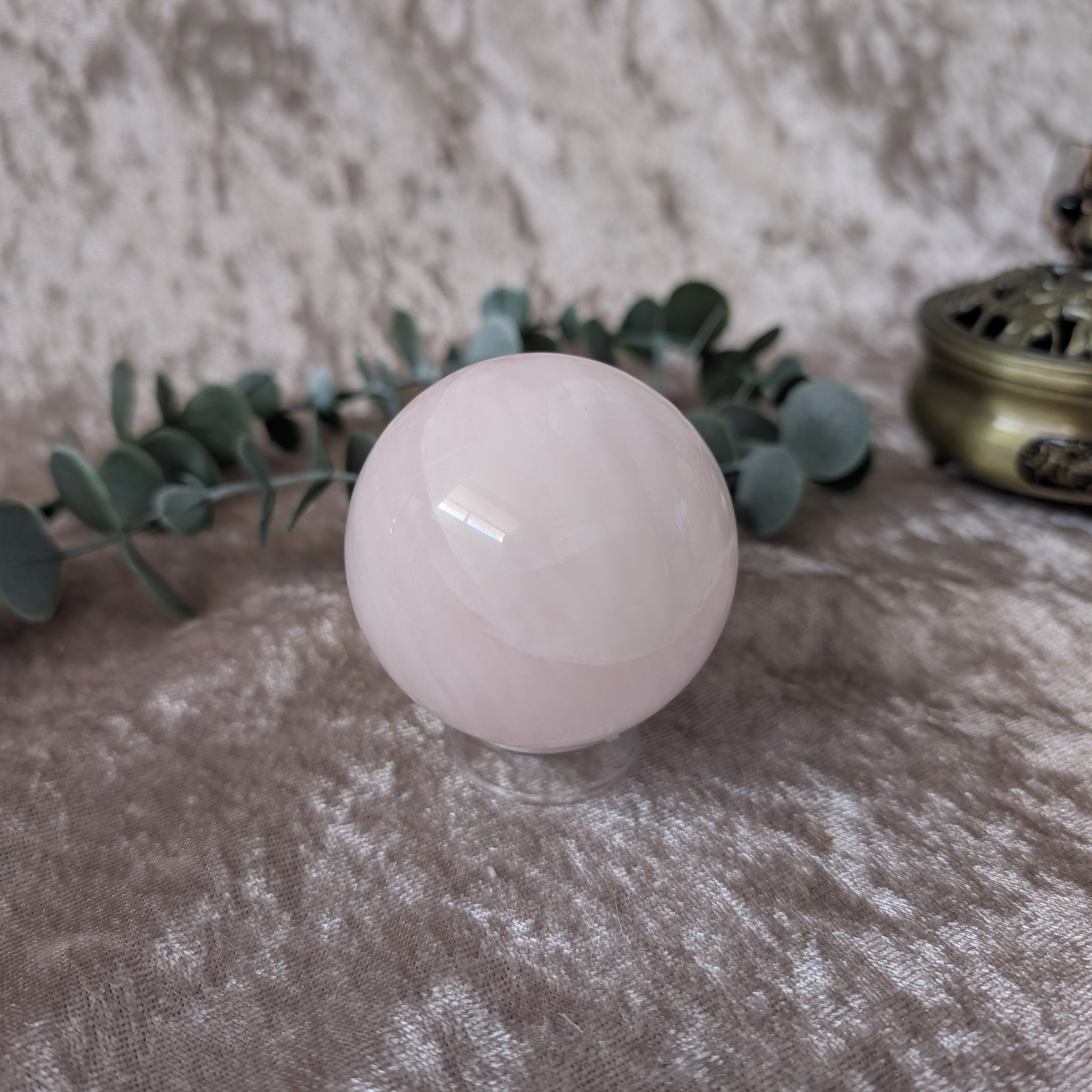 UV Reactive Mangano calcite sphere set on golden velvet background