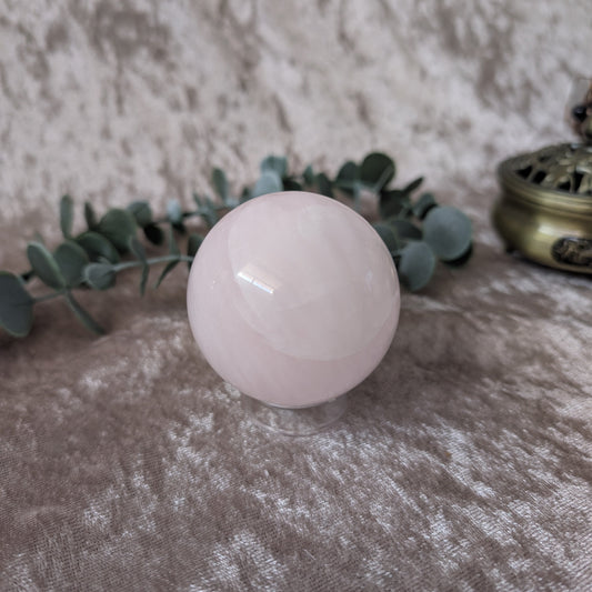 UV Reactive Mangano calcite sphere set on golden velvet background