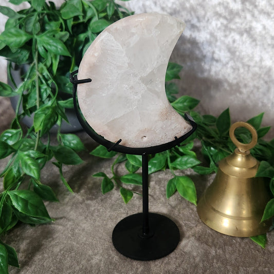 Clear Quartz moon carving on black stand with natural milky translucence