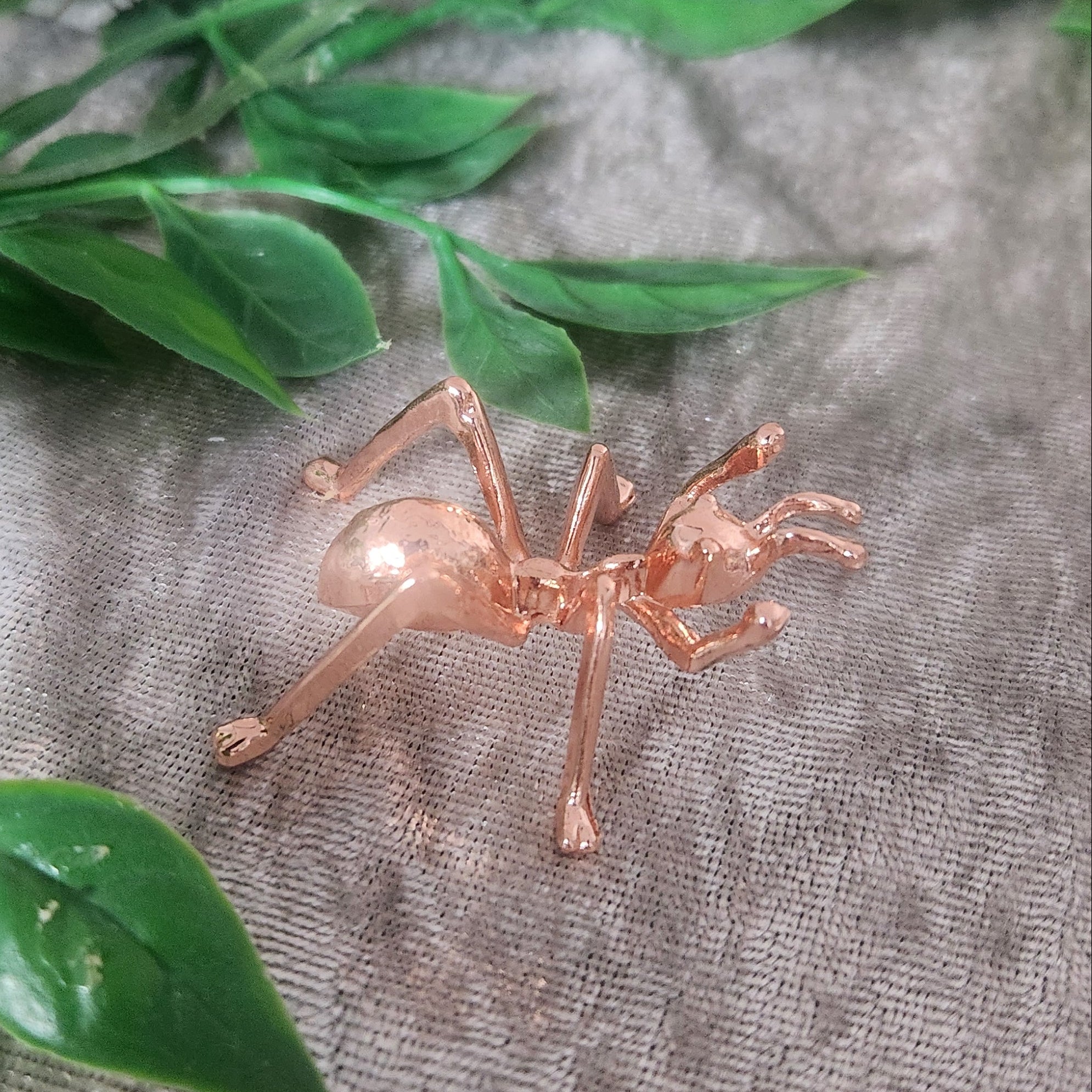 Rose gold ant sphere holder displaying crystal sphere on velvet cloth