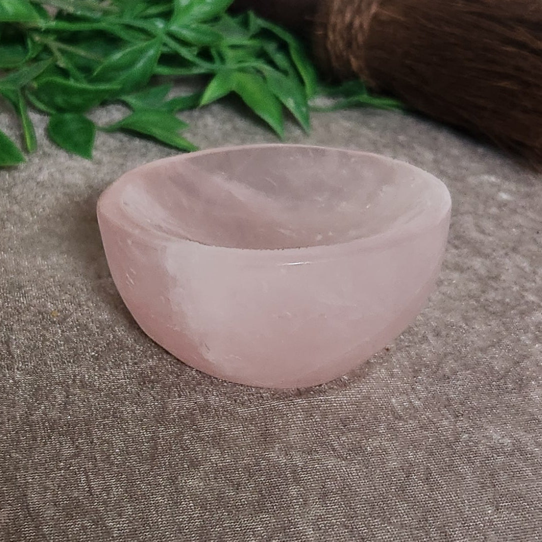 Close up of rose quartz bowl surface showing natural inclusions and polished crystal finish