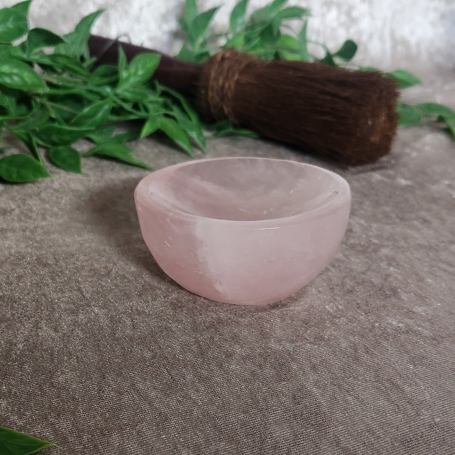 Side profile of rose quartz bowl showing curved shape and translucent natural stone texture