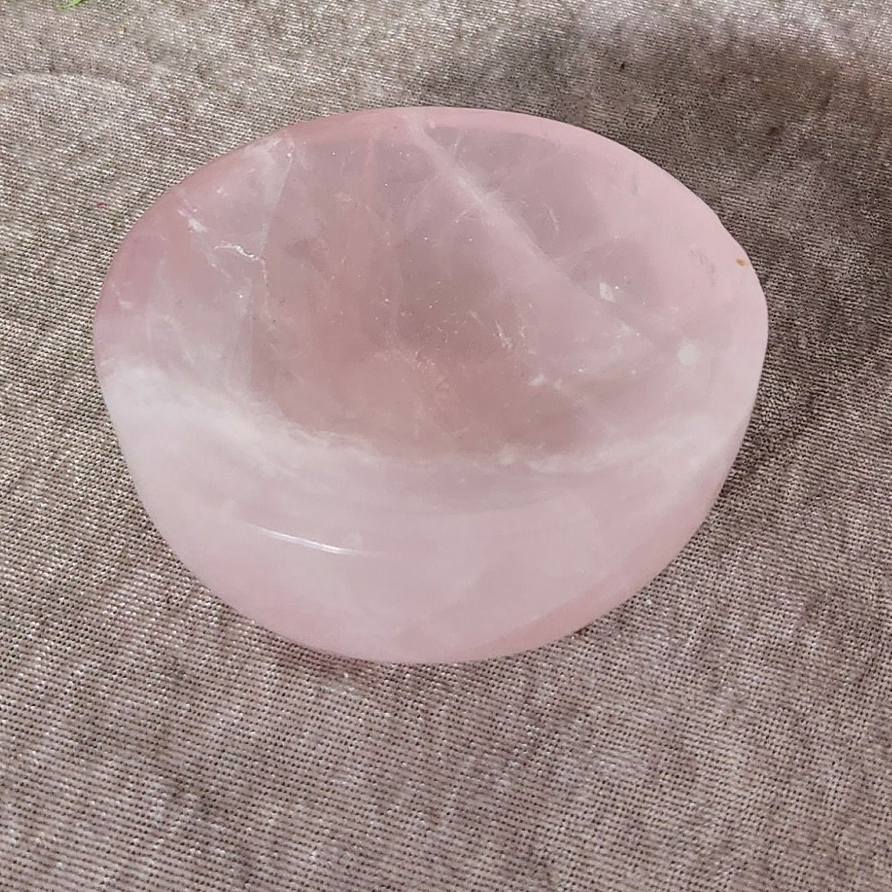 Angled view of rose quartz crystal bowl highlighting smooth polish and gentle pink colour