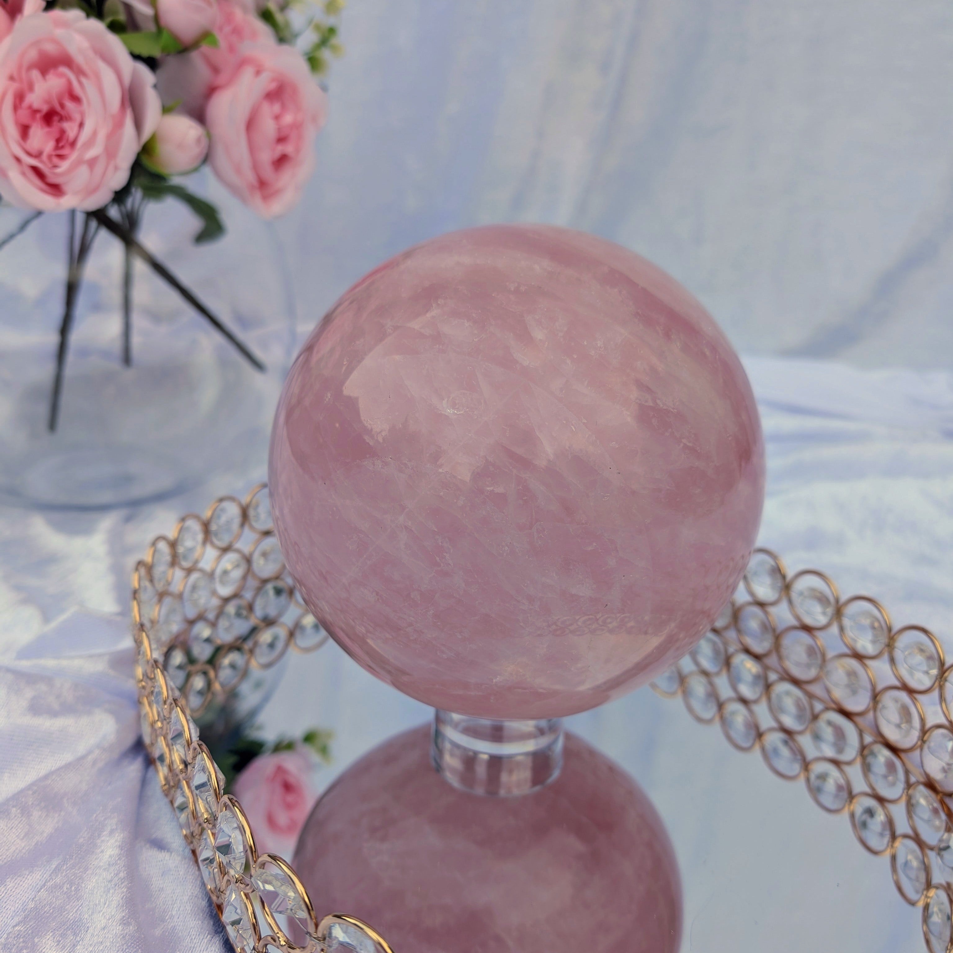 Rose Quartz Sphere – 4.38 kg statement crystal on mirrored tray with pastel floral styling, soft ambient lighting.