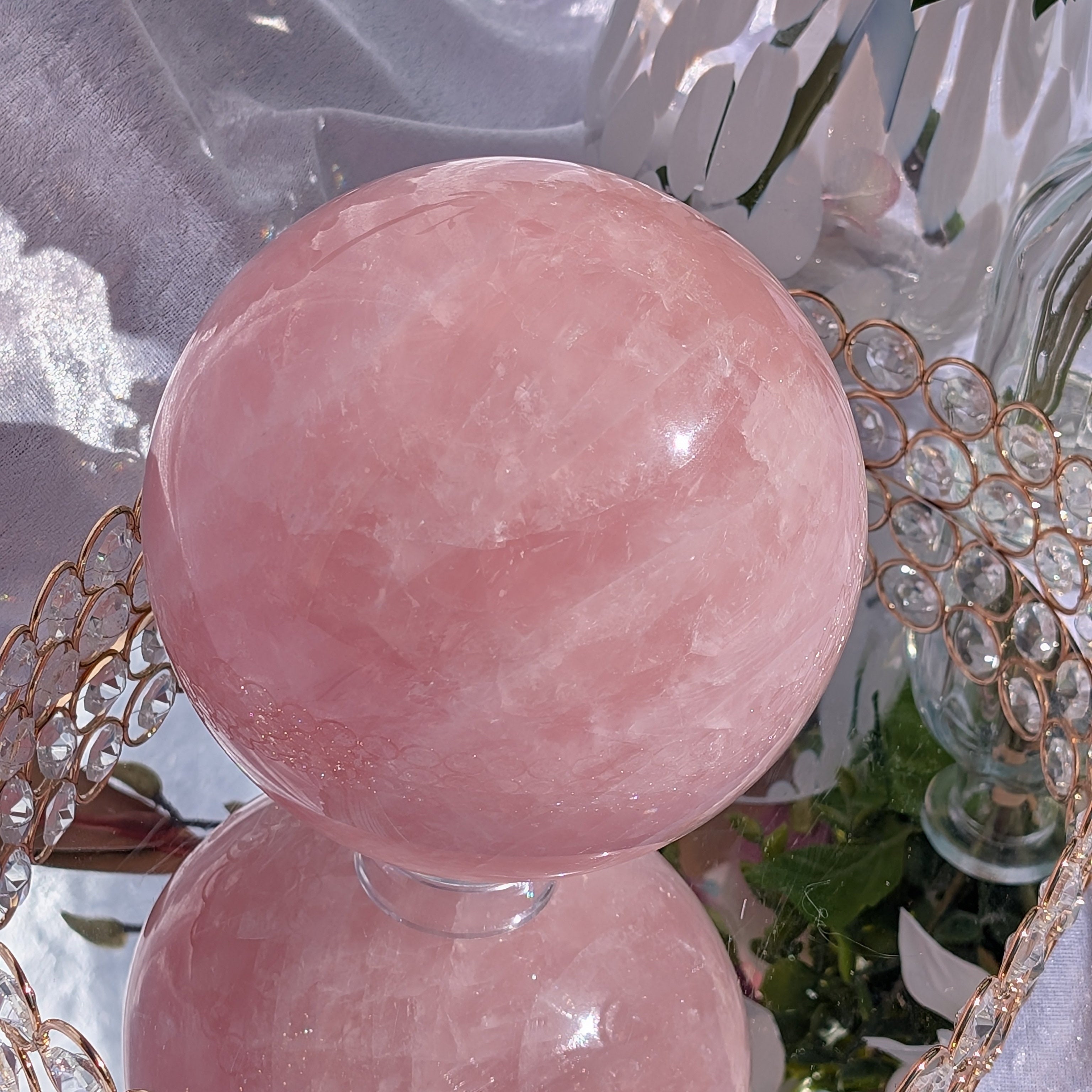 Rose Quartz Sphere – Large 4.38 kg piece displayed on crystal tray with soft pink florals and sunlight reflections.