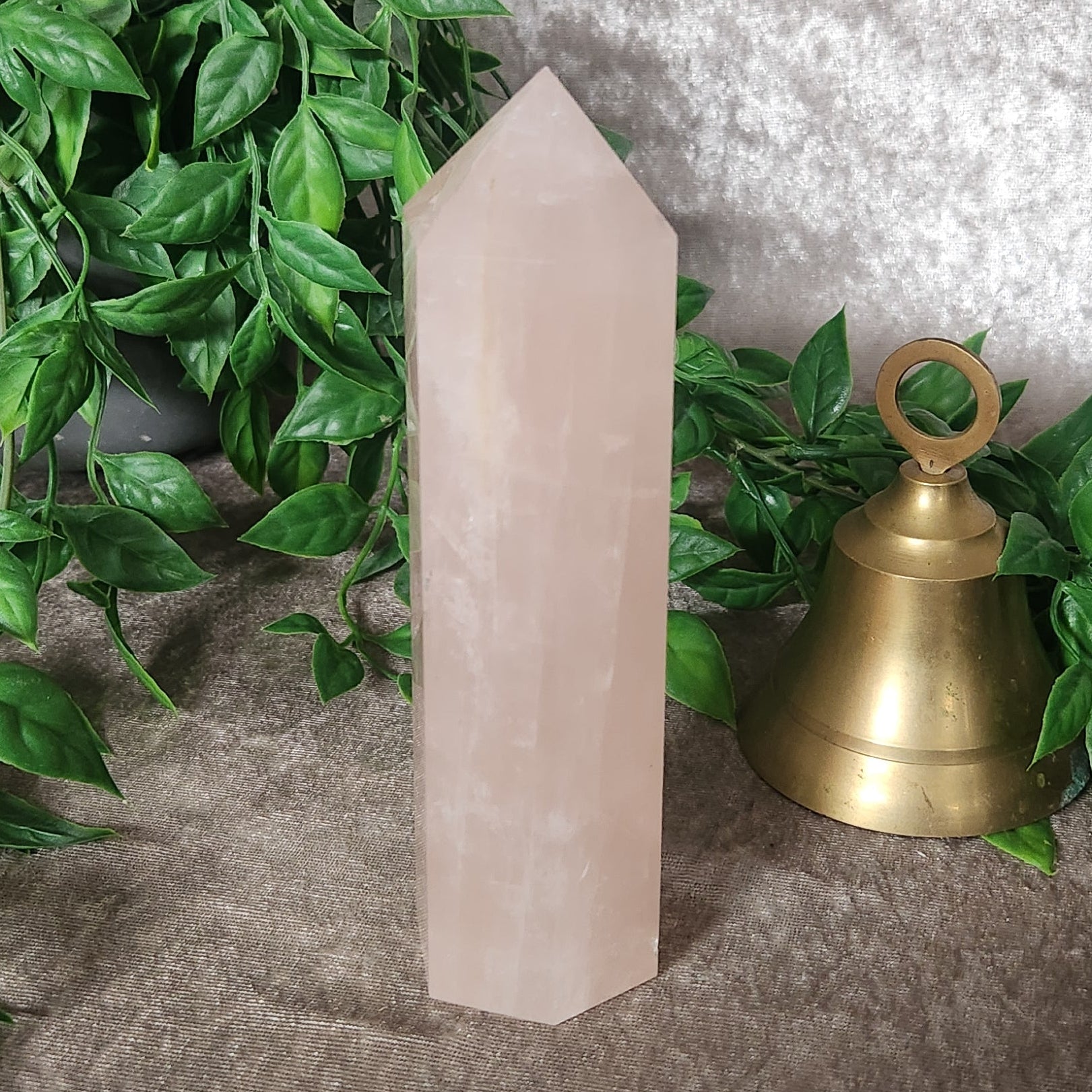 Rose quartz generator with soft blush tones polished to a smooth point
