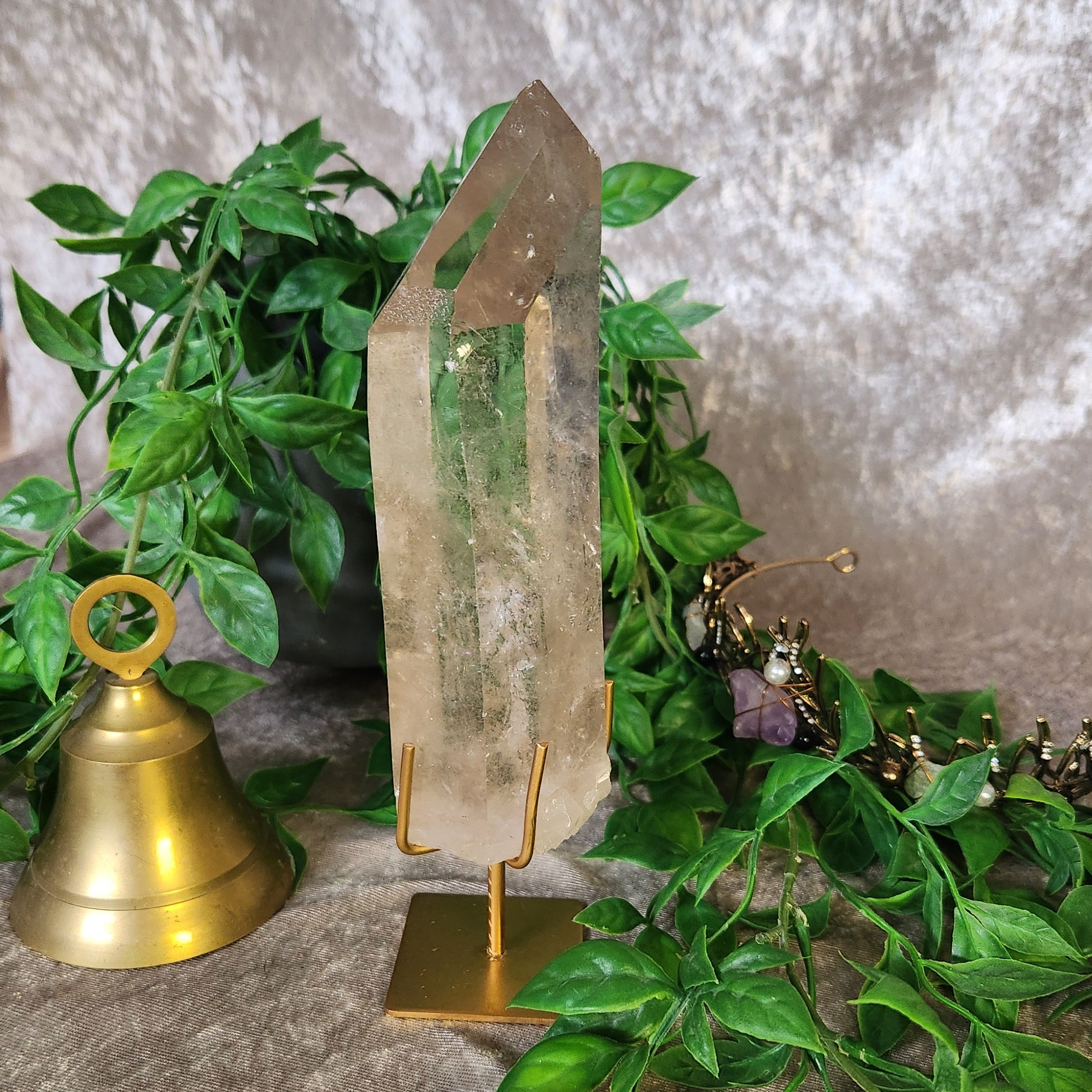 Natural clear quartz point showing internal formations, silver rutile and transparency