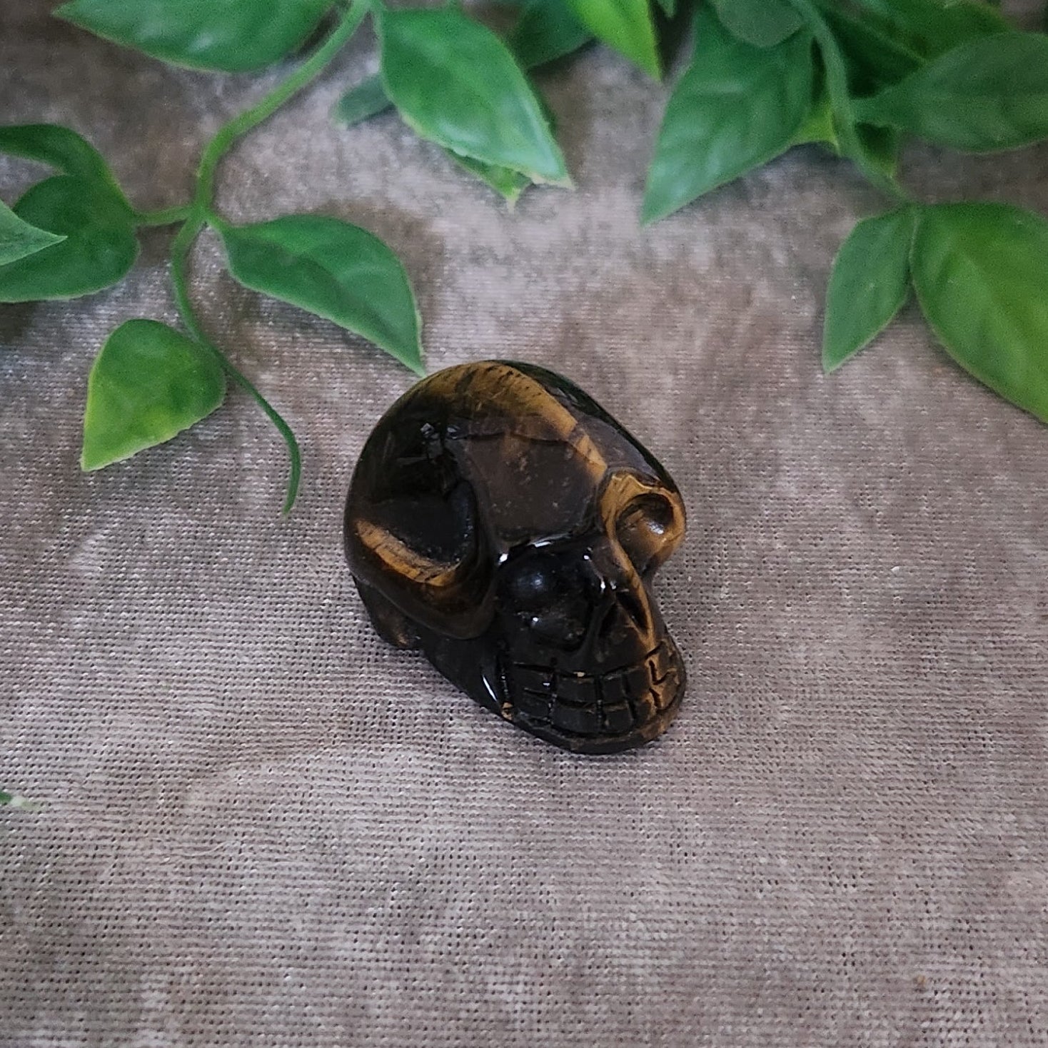Small Tiger’s Eye crystal skull symbolising protection and grounded confidence