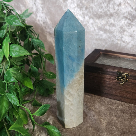 Troilite crystal tower photographed among greenery with a smooth polished finish