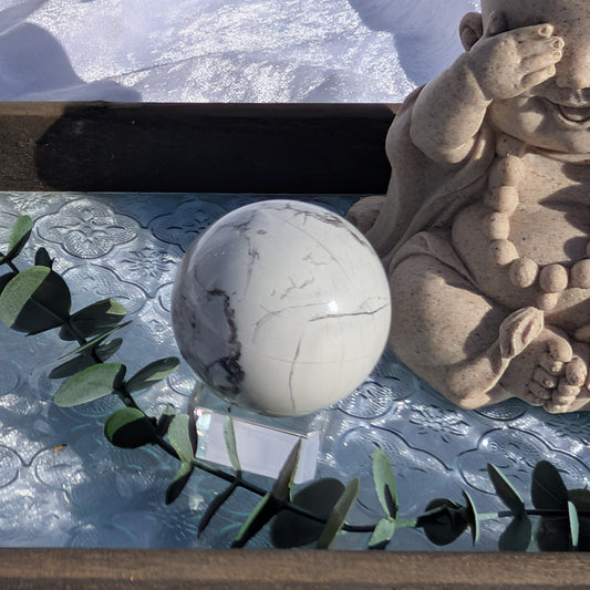 White Howlite Sphere displayed next to Buddha figure on vintage style glass tray