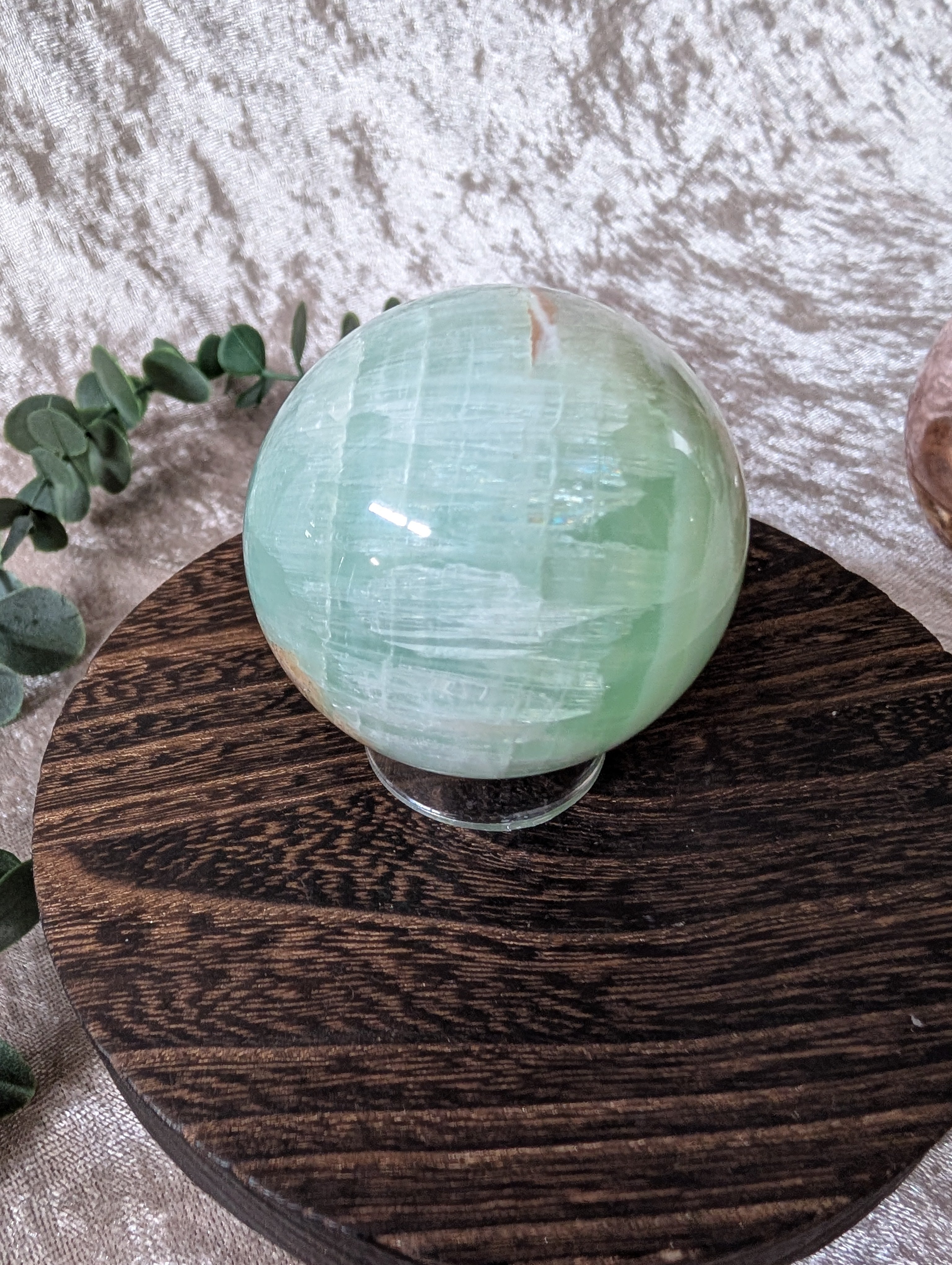 Sparkling Pistachio calcite sphere on wooden base, healing crystal décor