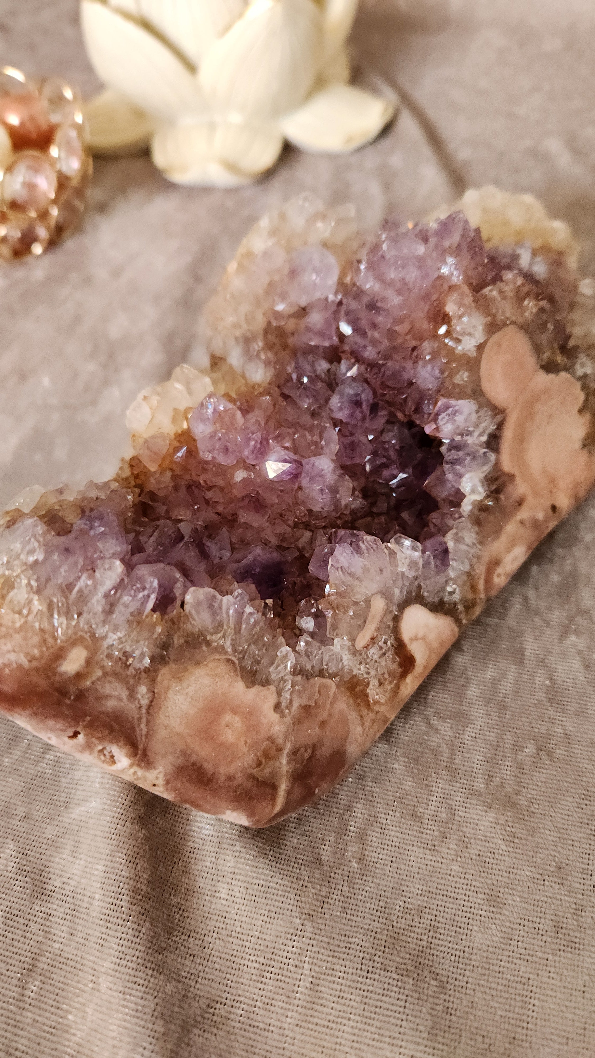 Pink Amethyst cluster with sparkling druzy points on neutral fabric background